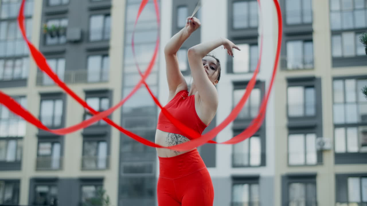 Woman Performing Ribbon Dance in Urban Setting