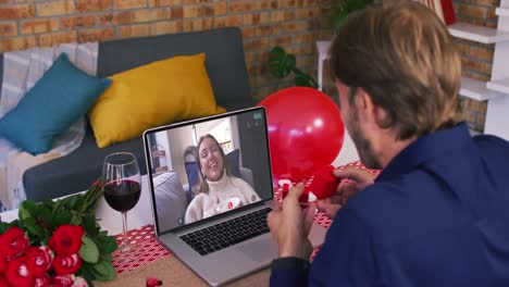 pareja caucásica en una cita de san valentín llamada de video hombre mostrando el anillo a la mujer sonriente en la pantalla del portátil