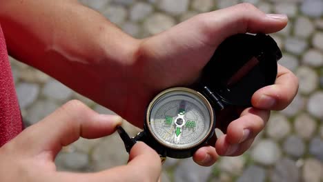 a young man takes out a compass and opens it