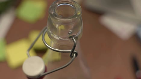 botella de vidrio con agua en la oficina