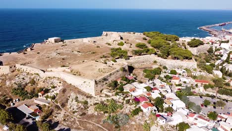 Rethymno-township-and-coastal-fortress,-aerial-orbit-view