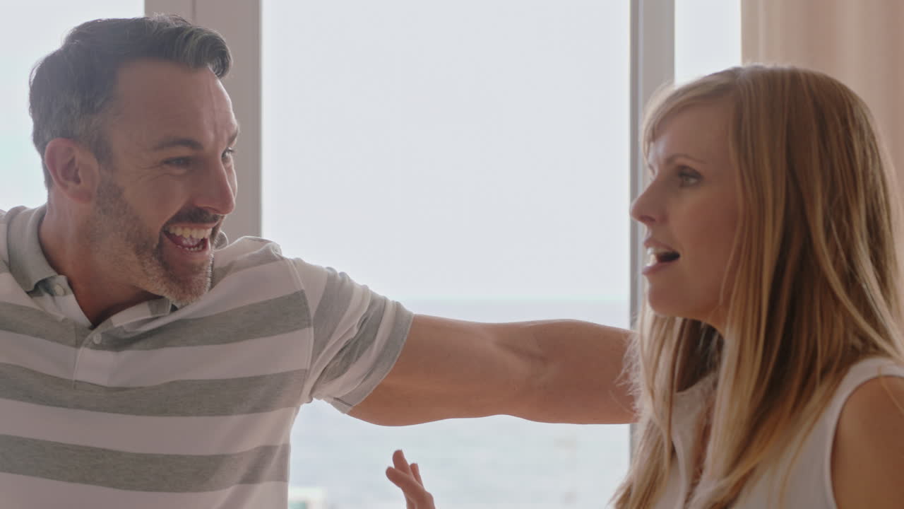 pareja joven mudándose de casa nuevos dueños de casa sonriendo disfrutando de una mudanza exitosa abrazándose en el apartamento