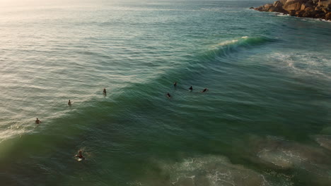 surfers floating on the ocean at llandudno, cape town, south africa - aerial drone shot