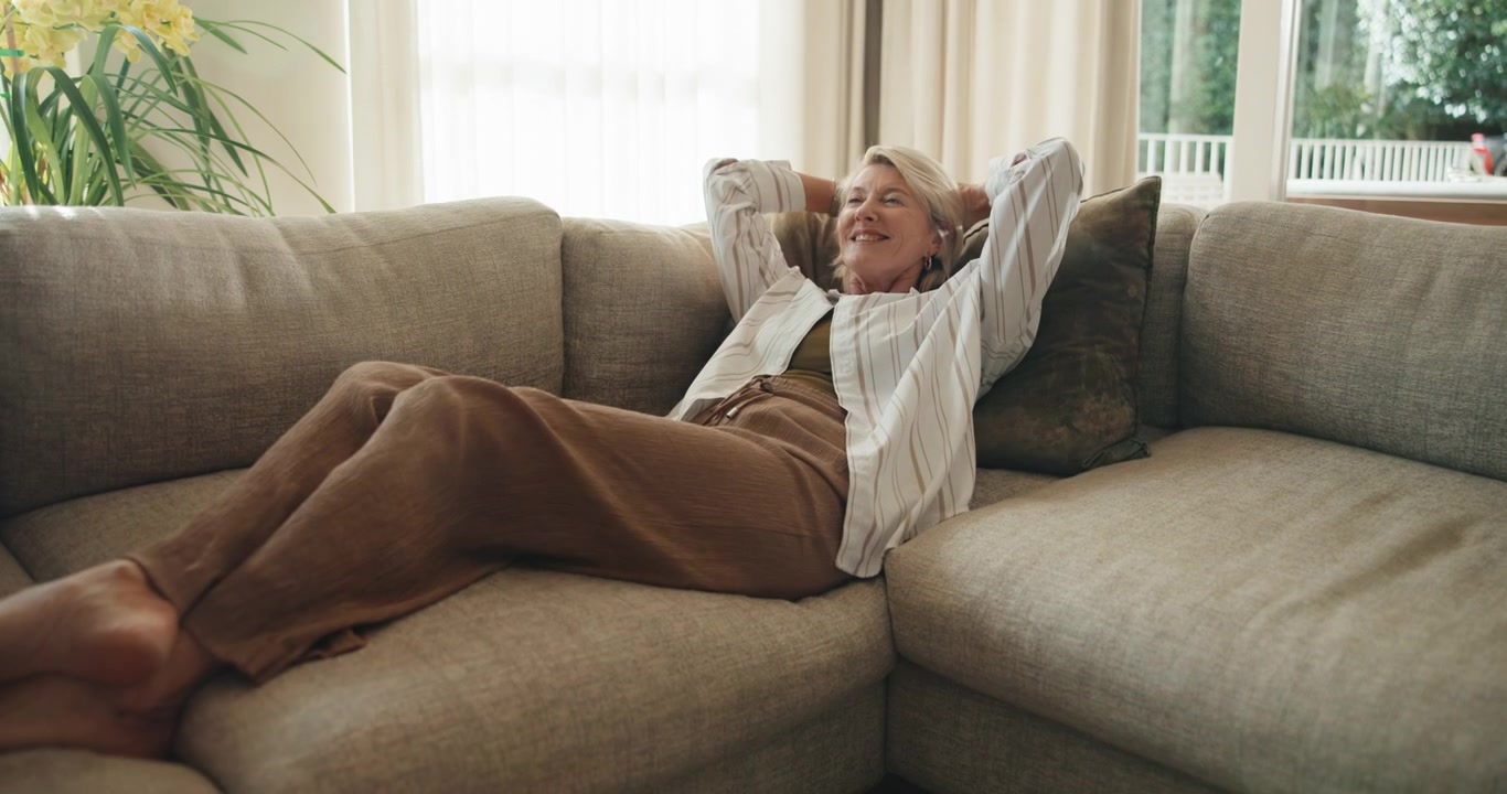 Mature Woman Relaxing on Sofa at Home