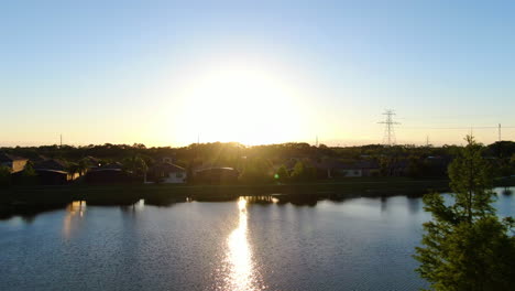 Panorámica-Sobre-Las-Casas-Junto-Al-Lago-Para-Revelar-La-Hermosa-Puesta-De-Sol-Primaveral-De-Florida