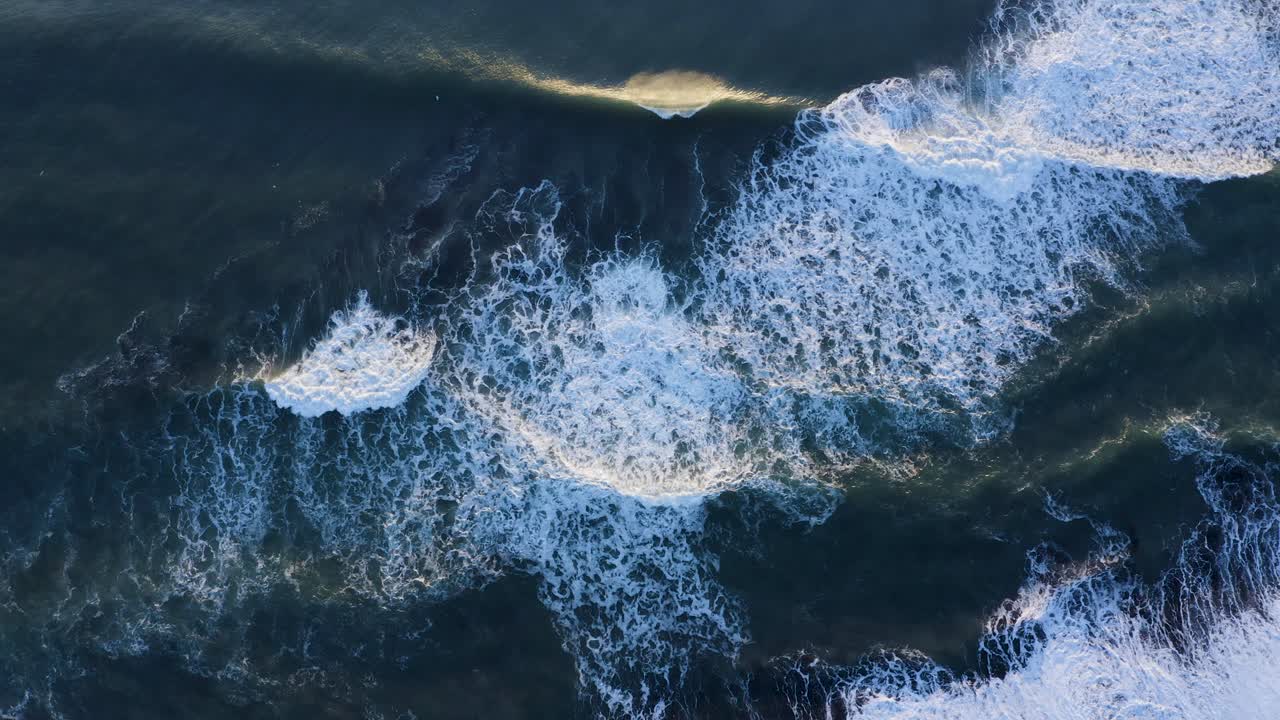 조용하고 한적한 남쪽 해안 해변의 검은 모래 해안에 부서지는 파도 - 공중 드론
