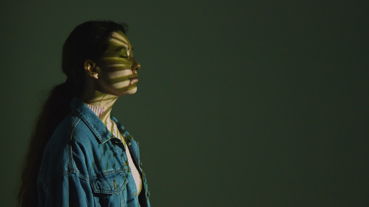 женщина посещает захватывающую художественную выставку с изображениями пальмовых листьев, проецируемых на ее лицо