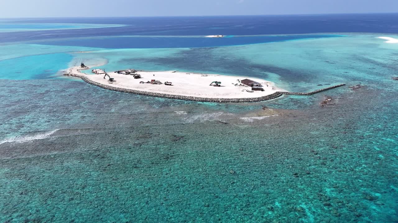 Luftfoto fra drone af ø-inddæmning og resortbyggeri på Maldiverne.
