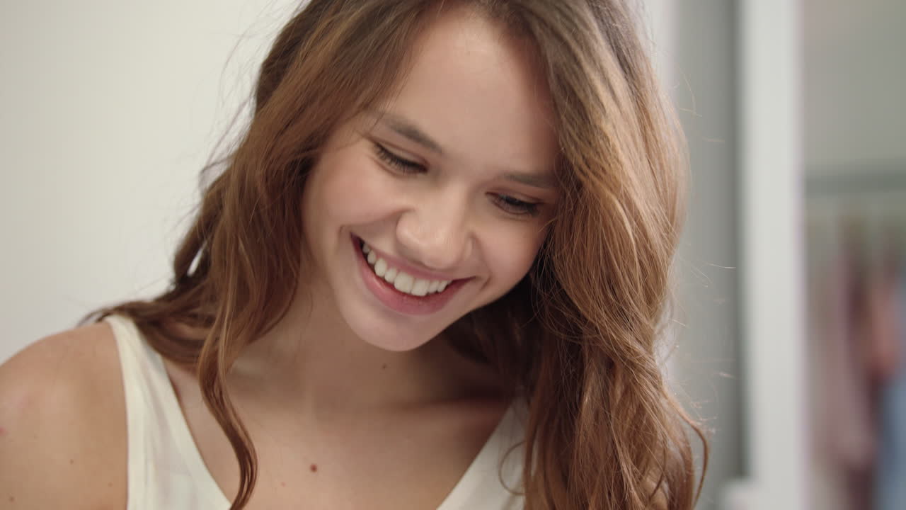 Portrait of happy woman smiling in bedroom