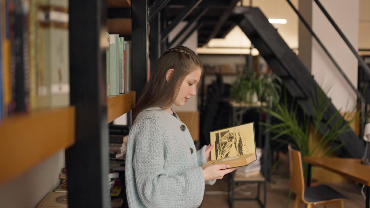 Teenage girl reading in a modern library cafe