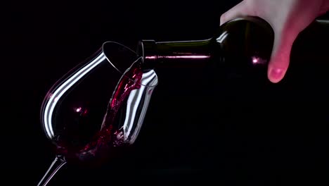 red wine being poured from a bottle into a wine glass