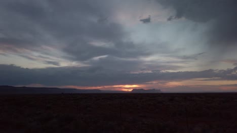 Tiro-Panorámico-Lento-A-Través-Del-Horizonte-Durante-Una-Tormentosa-Puesta-De-Sol-En-El-Desierto-Al-Atardecer