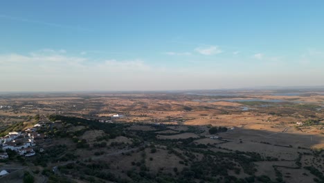 aerial view of a rural landscape with a village and reservoir