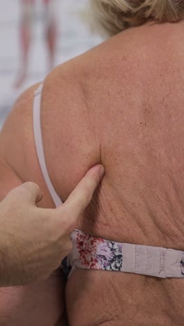 closeup of a medical worker performing a thorough examination of the back of an elderly patient in a closeup of a medical worker performing a thorough examination of the back of an elderly patient in a clinic