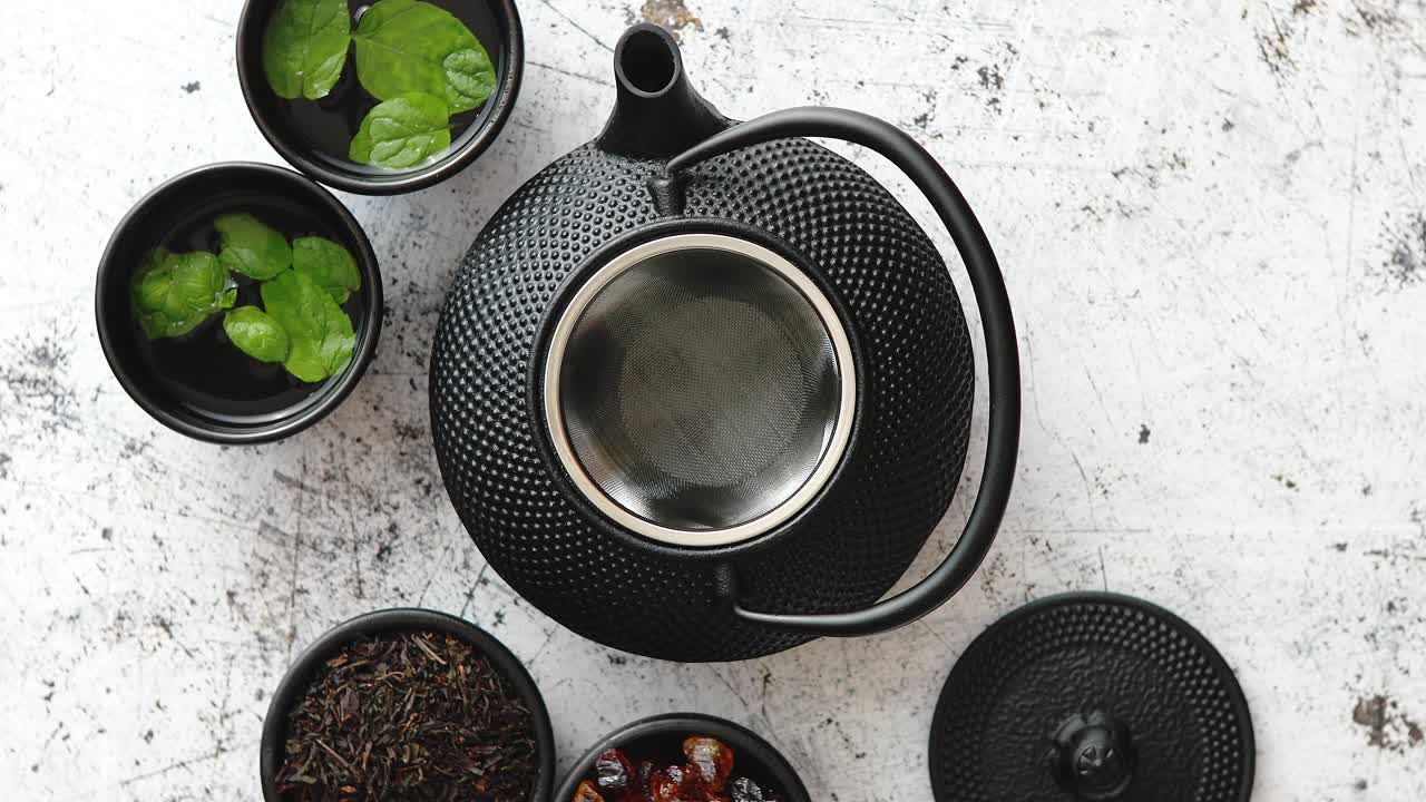 tetera de metal oriental tradicional y tazas de hierro