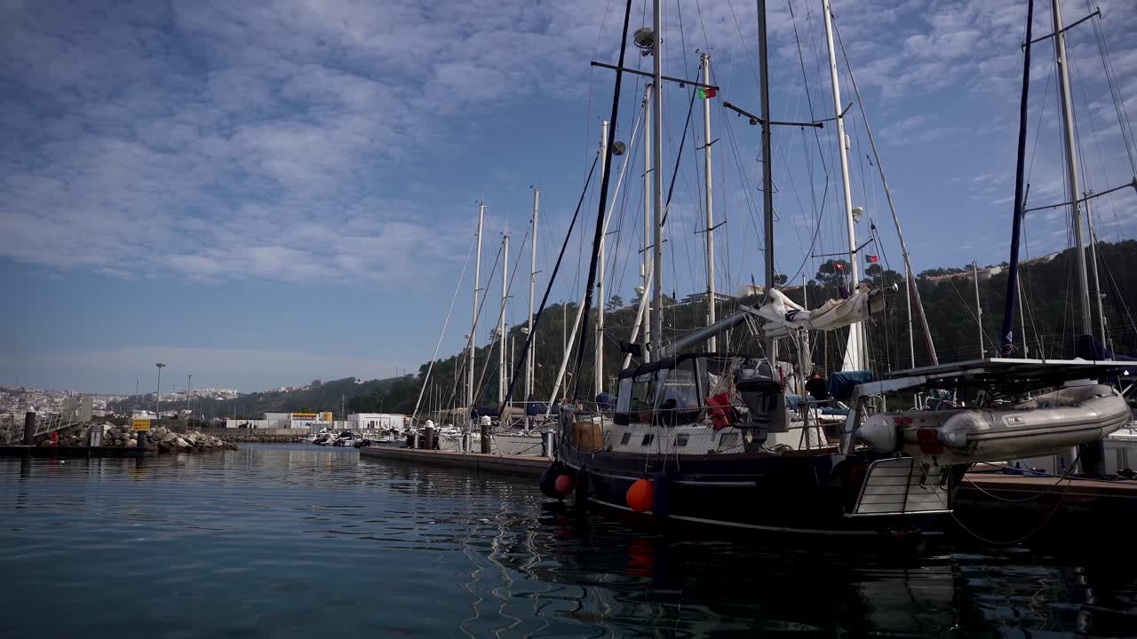 Vista dinamica sulla marina di Nazaré, barche a vela ancorate al molo, Portogallo.