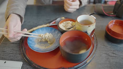 Frisches-Warabimochi,-Bedeckt-Mit-Kinako,-In-Zeitlupe-Von-Stäbchen-Aufgenommen