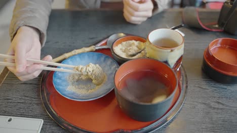 키나코로 덮인 신선한 와라비모찌, 젓가락으로 슬로우 모션으로 집음