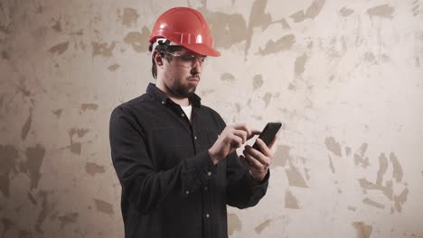construction worker checking details on smartphone