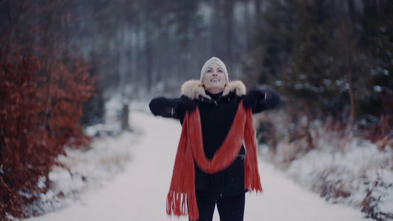 눈에 점프하고 겨울에 스카프를 가지고 노는 긍정적 인 여자 3