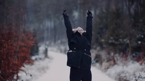 positive woman jumping on snow and playing with scarf in winter 3