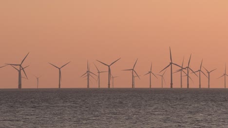 aerial view of wind turbines farm in sunset to produce clean renewable sustainable energy target netzero