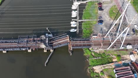 Aerial-view-of-Railroad-Draw-Bridge-closing-over-Cheesequake-Creek-in-Morgan,-NJ