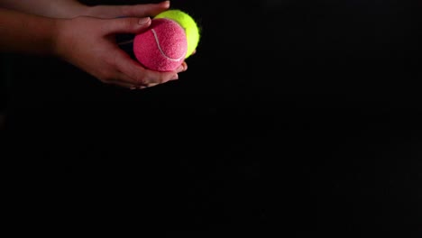 three tennis balls bouncing on black surface