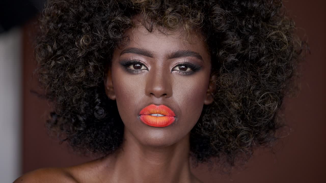 mujer africana con maquillaje audaz y cabello rizado