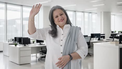 happy indian senior businesswoman waving and saying hello