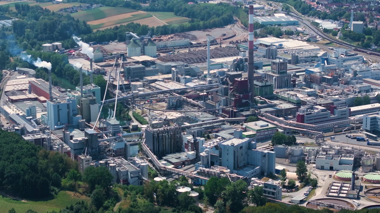Vast industrial complex of Lenzing Plastics in Austria, showing the polymer and thermoplastic production facilities with smoking chimneys
