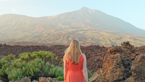 Mujer-Vestida-De-Naranja-Explora-El-Paisaje-Volcánico-Del-Teide,-Tenerife