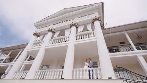 una pareja posando en un balcón de un hermoso edificio