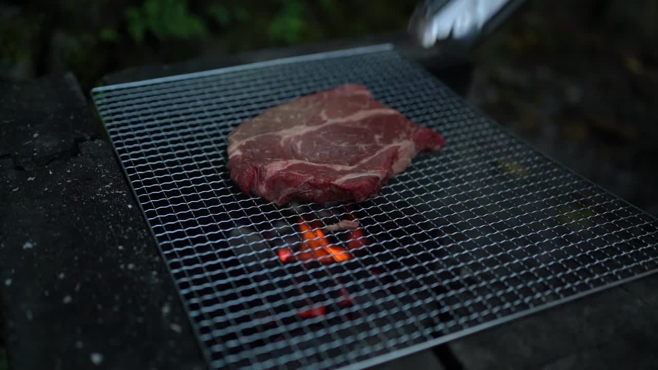 Beef steak on the grill with flames. BBQ concept. Slow motion
