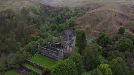 campbell castle: aerial shot approaching the scottish castle and making out the outer grove of the area