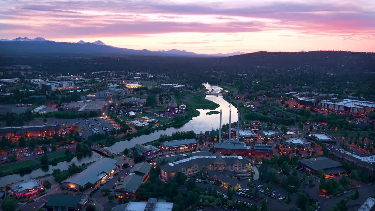 Beautiful sunset over the mountain range surrounding Bend, Oregon, USA. Slow drone orbit over Old Mill District.