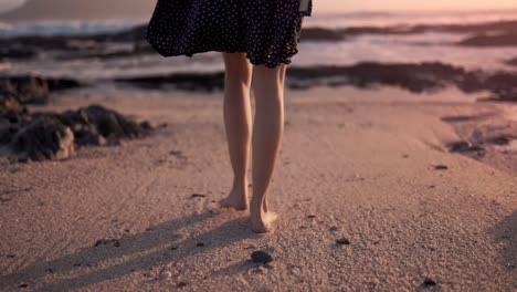 Cinematic-shot-of-a-skinny-Caucasian-girl-walking-in-the-beach-during-a-majestic-sundown-and-golden-hour