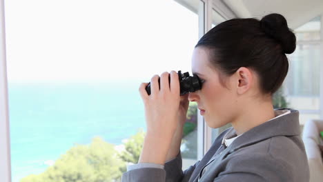 mujer de negocios mirando a través de un binocular