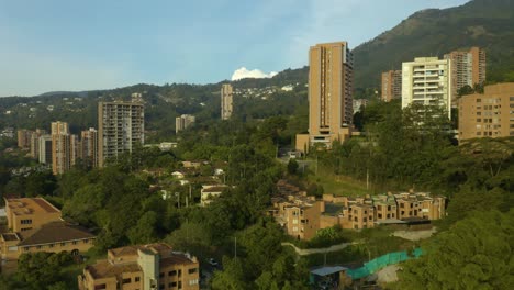 low aerial flight over condo buildings on lush mountainside, colombia