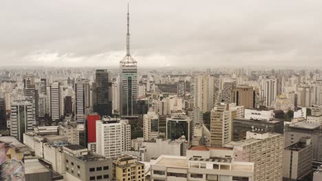 Rising-drone-shot-showing-business-district-with-high-rise-tower-in-downtown-of-Sao-Paulo,-Brazil