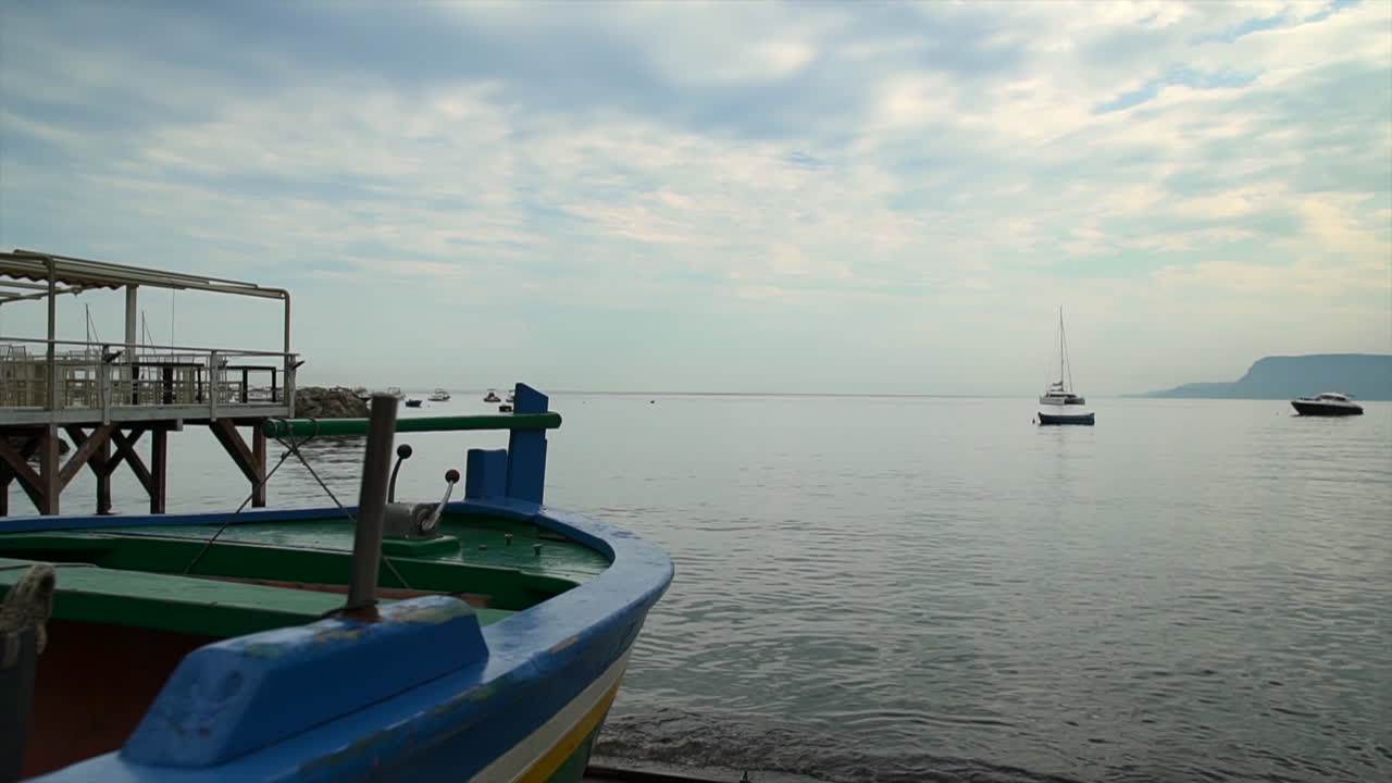 retroceso lento junto a un colorido barco de pesca de madera en la orilla de la tranquila bahía