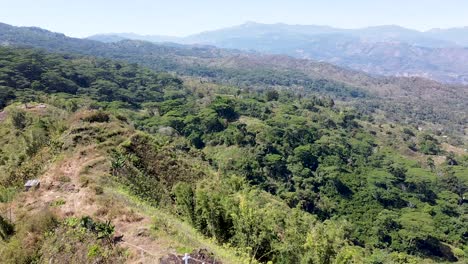 aerial rising over 3 white crosses crucifix in the mountains of timor leste, southeast asia with highest mountain mt ramelau in the distance