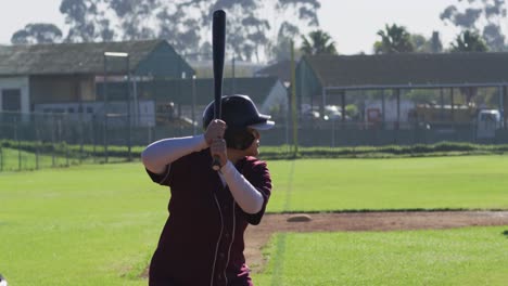 Mixed-race-female-baseball-player,-hitter,-swinging-bat-for-pitched-ball