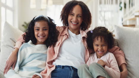 a happy family of three smiles for the camera in a cozy living room.