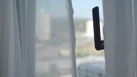 ventana con cortinas blancas y vista a la ciudad