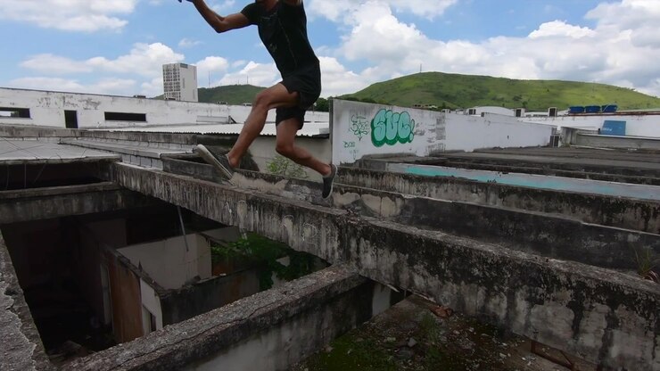 Un freerunner salta da un tetto per fuggire da un edificio