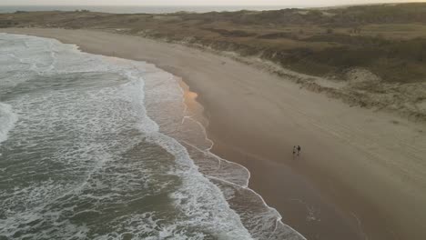 Pareja-Caminando-En-La-Playa-Al-Atardecer,-Playa-La-Viuda