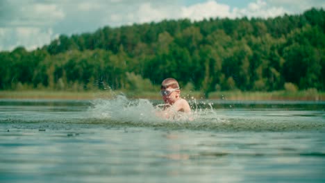 joyful kid with swim gear outburst water on the lake with nature background