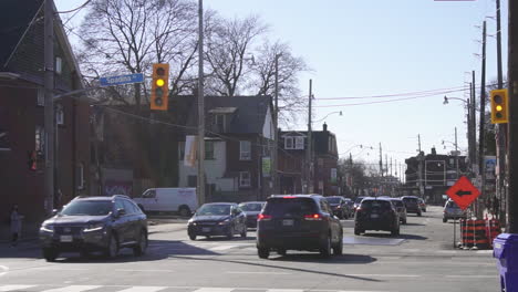 cars driving on non descript city street in the morning in fall