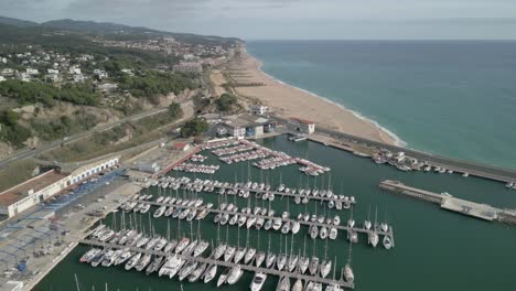 Puerto-Deportivo-De-Arenys-De-Mar-En-El-Maresme-Provincia-De-Barcelona-Pequeñas-Embarcaciones-Amarradas-Pueblo-Pesquero-Imágenes-Aéreas